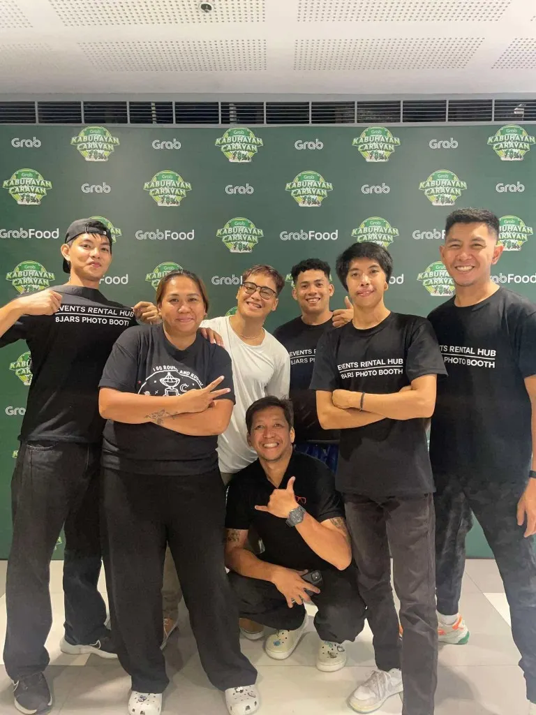 Events Rental Hub team in branded shirts posing in front of a Grab Kabuhayan Caravan event backdrop